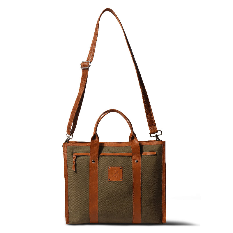 Brown leather and fabric tote bag with shoulder strap on a white background