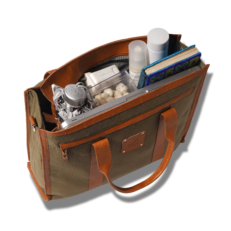 Open brown tote bag with various items on a white background