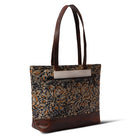 Tote bag with floral pattern and brown leather accents on a white background