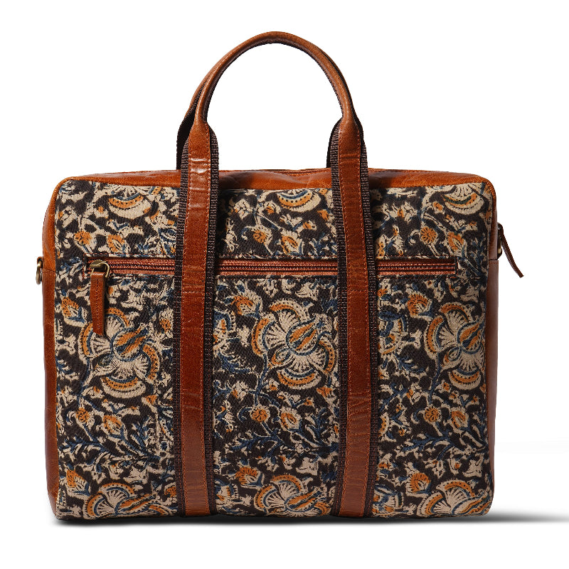 Floral patterned bag with brown leather straps on a white background