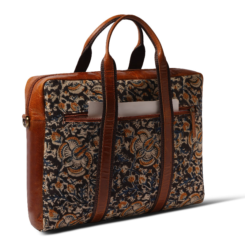 Floral patterned bag with brown leather straps on a white background
