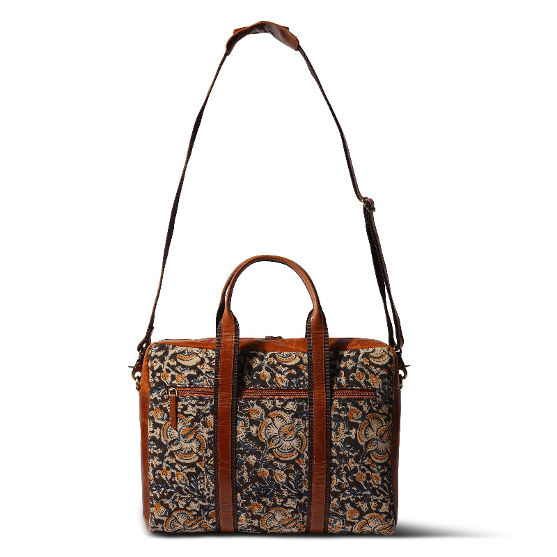 Patterned bag with brown handles and strap on a white background