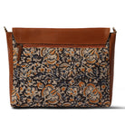 Floral patterned bag with brown leather accents on a white background