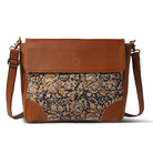 Brown leather bag with floral patterned flap on a white background