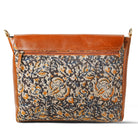 Handbag with floral pattern and brown leather accents on a white background
