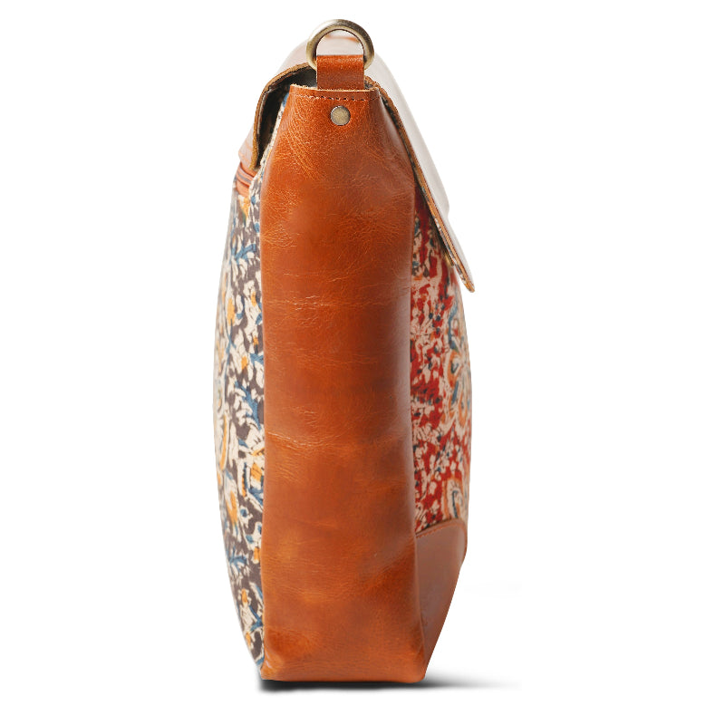 Handbag with floral pattern and brown leather strap on a white background