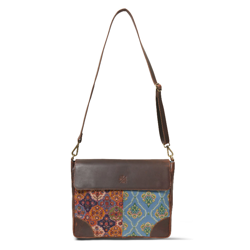 Brown leather crossbody bag with colorful patchwork design on a white background