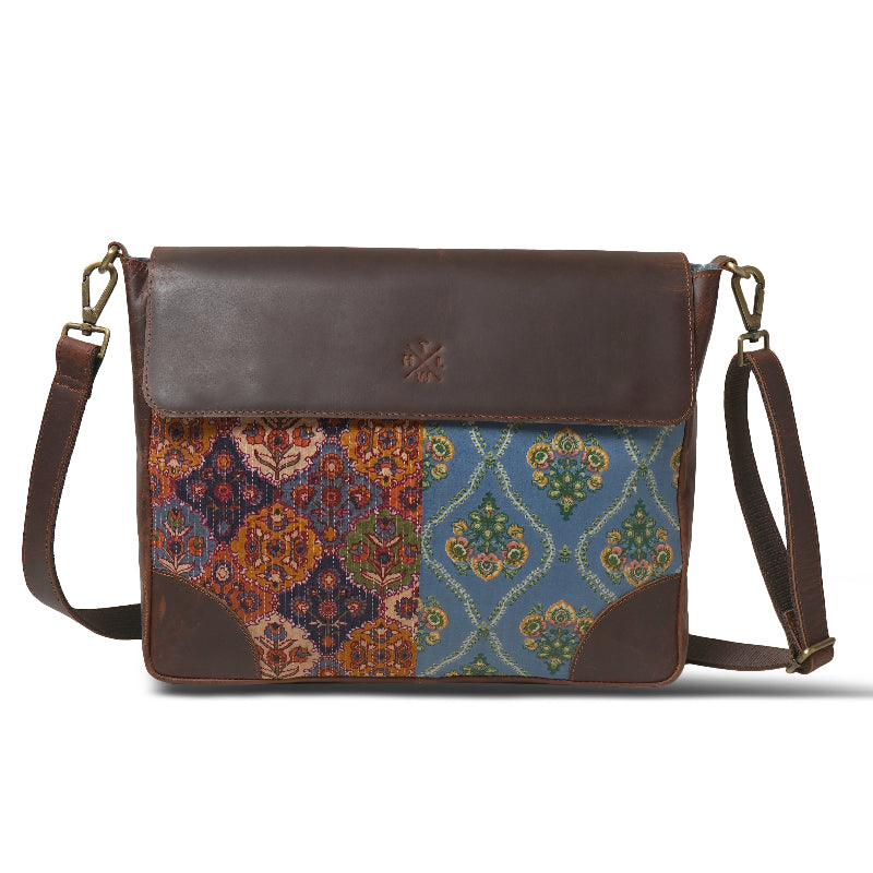 Brown leather bag with colorful patterned flap on a white background