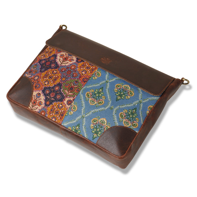 Floral patterned pouch with brown leather accents on a white background