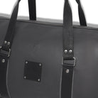 Black leather bag with straps on a white background
