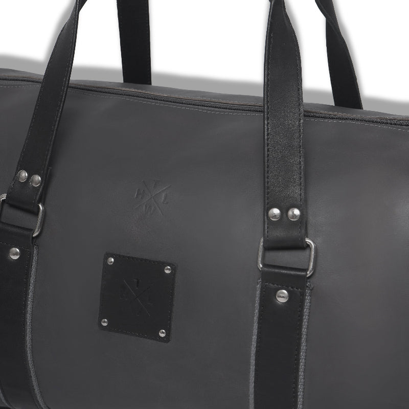 Black leather bag with straps on a white background