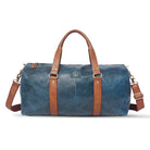 Blue duffel bag with brown straps and handle on a white background