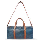 Blue duffel bag with brown leather straps on a white background