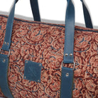Patterned bag with blue straps on a white background