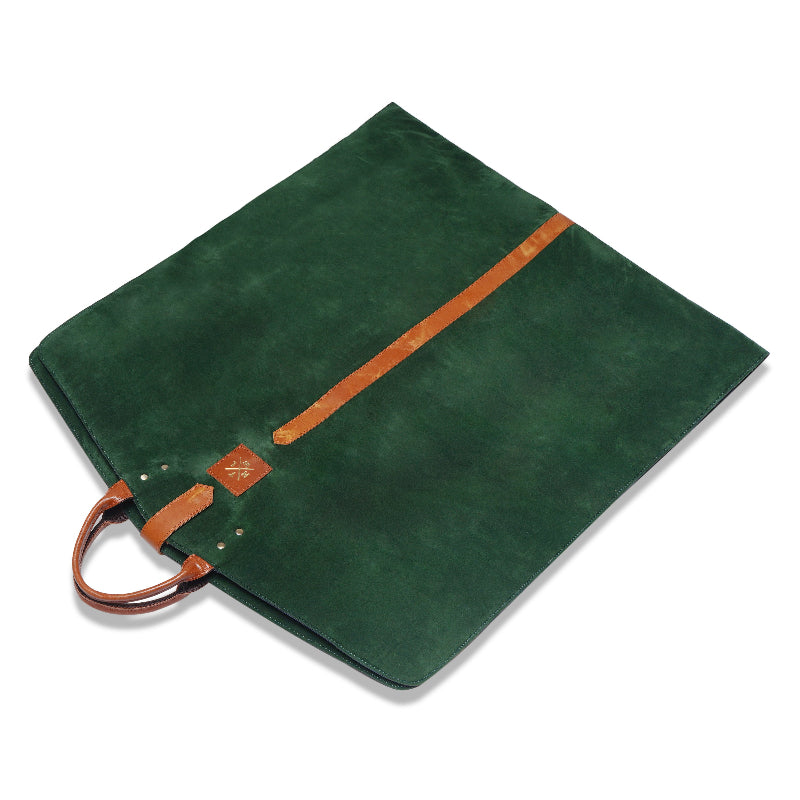 Green hanging bag  with brown leather accents on a white background