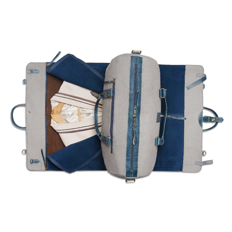 Open suitcase with clothes and a folded jacket on a white background