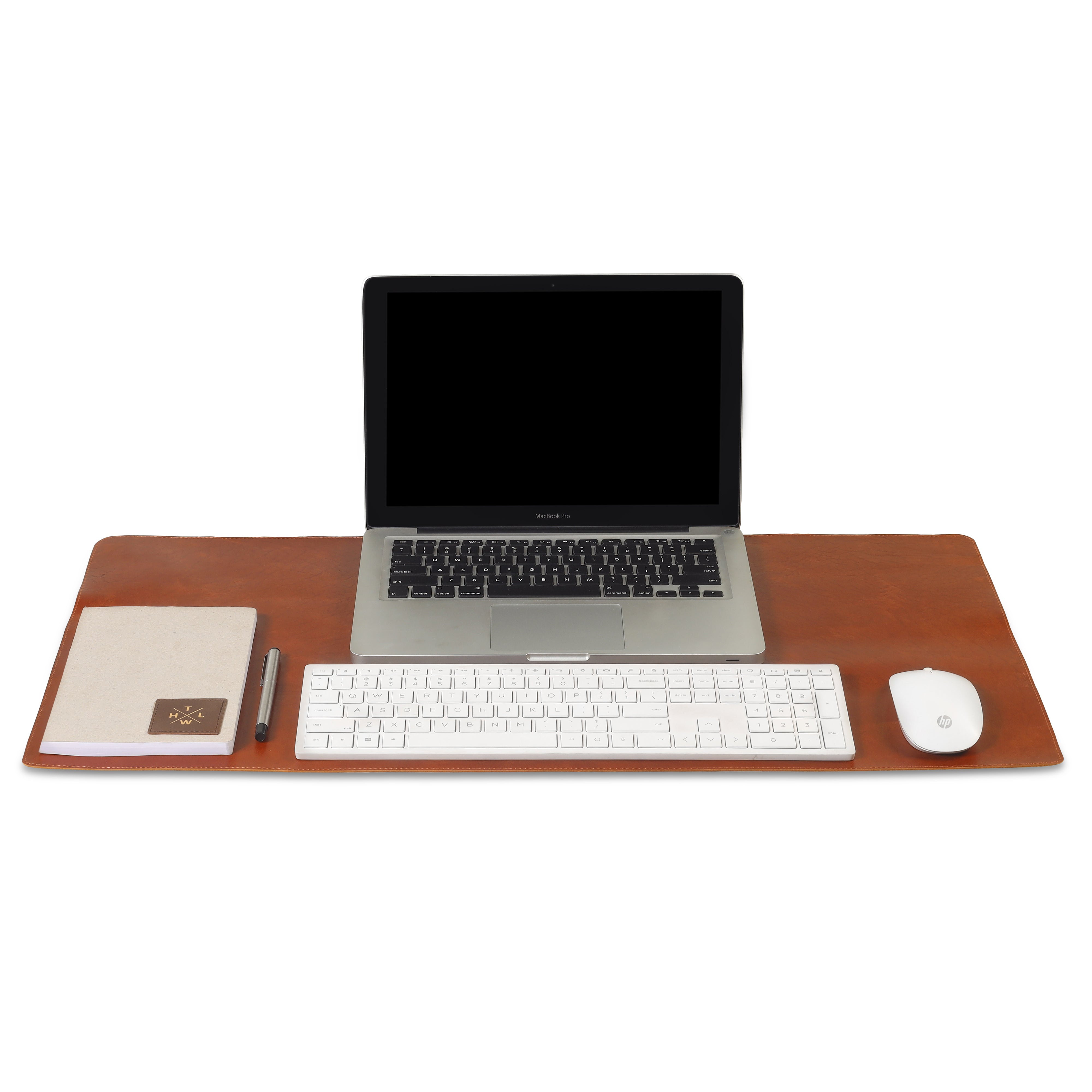 A brown leather desk mat with a MacBook Pro, wireless keyboard, mouse, notebook, and pen neatly arranged on top.
