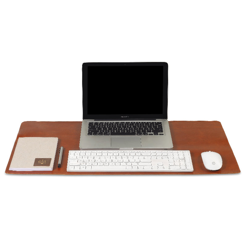 Laptop on a brown desk with keyboard, mouse, and stationery on a white background