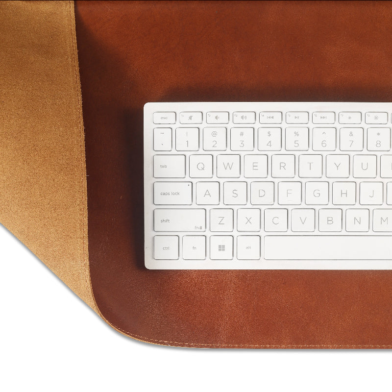 White keyboard on a brown leather desk mat