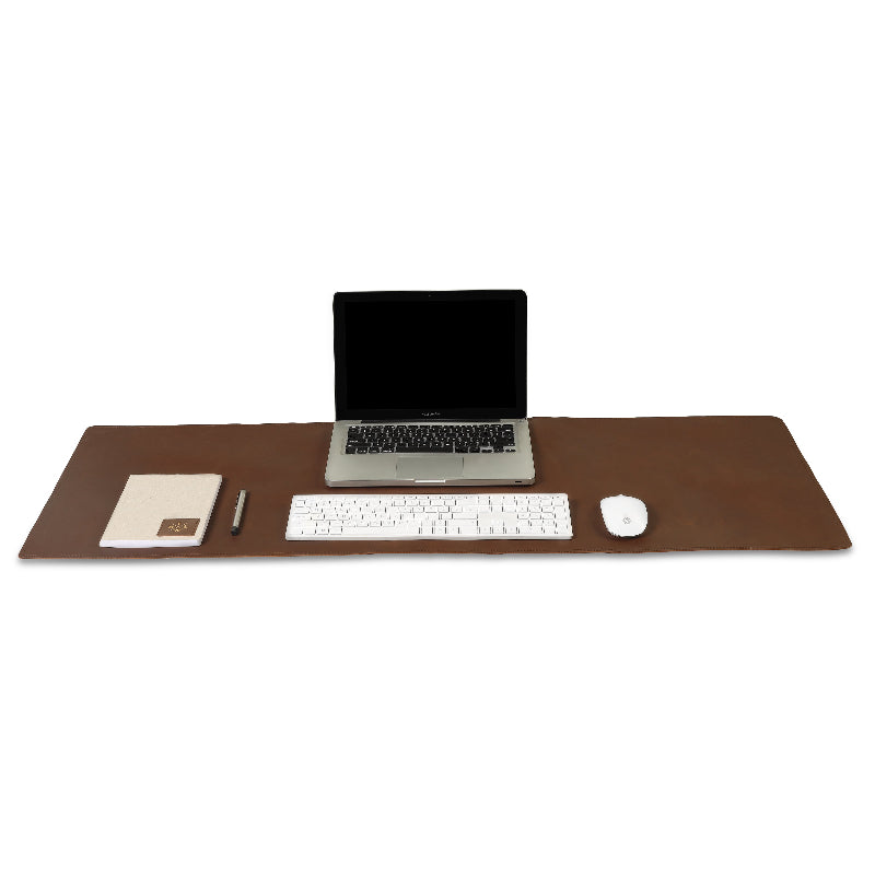 Brown desk mat with laptop, keyboard, mouse, and pen on a white background