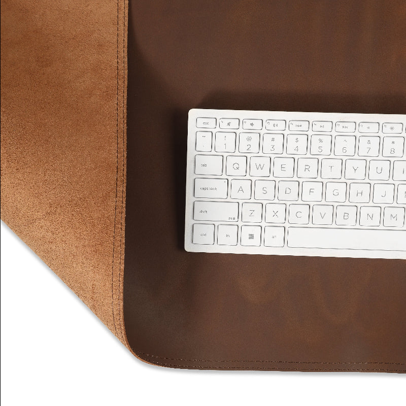 White keyboard on a brown leather desk mat