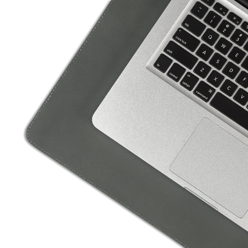 Laptop on a gray desk pad with a white background