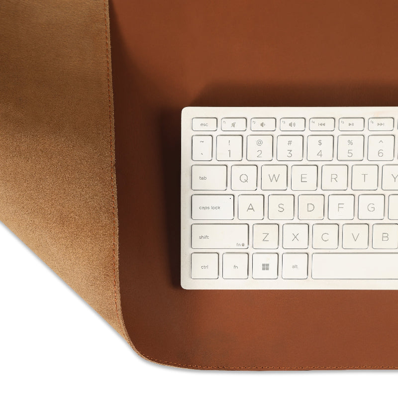 White keyboard on a brown leather desk mat