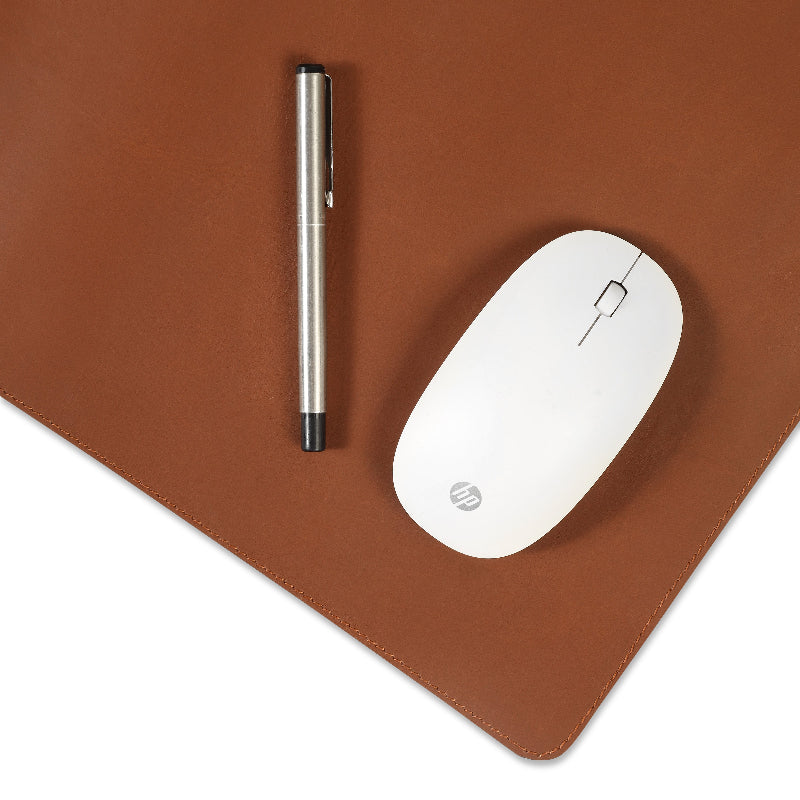 White mouse and pen on a brown leather desk pad