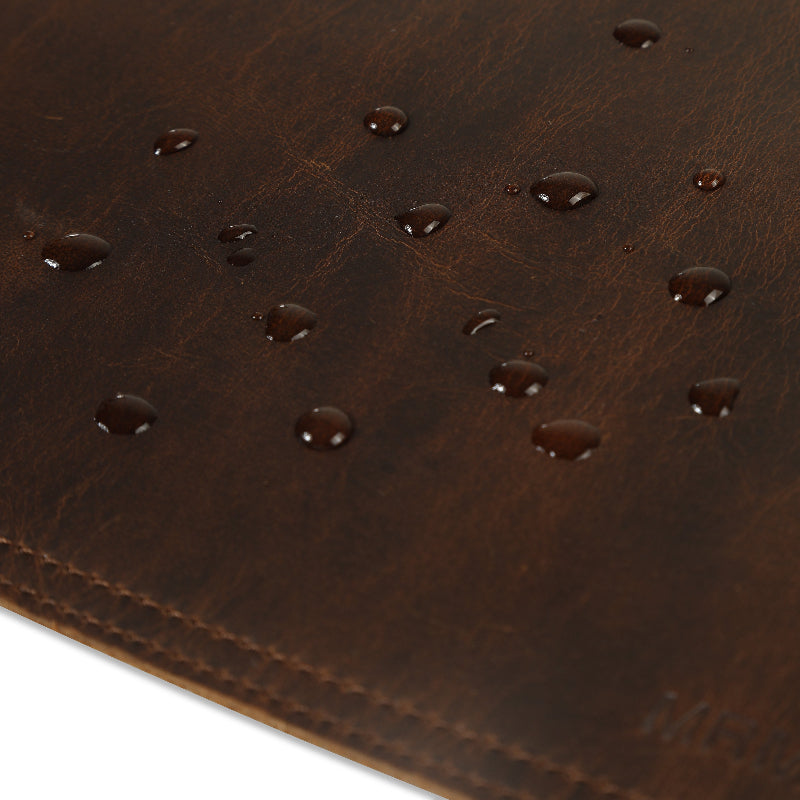 Close-up of a brown leather dask mat with water droplets.