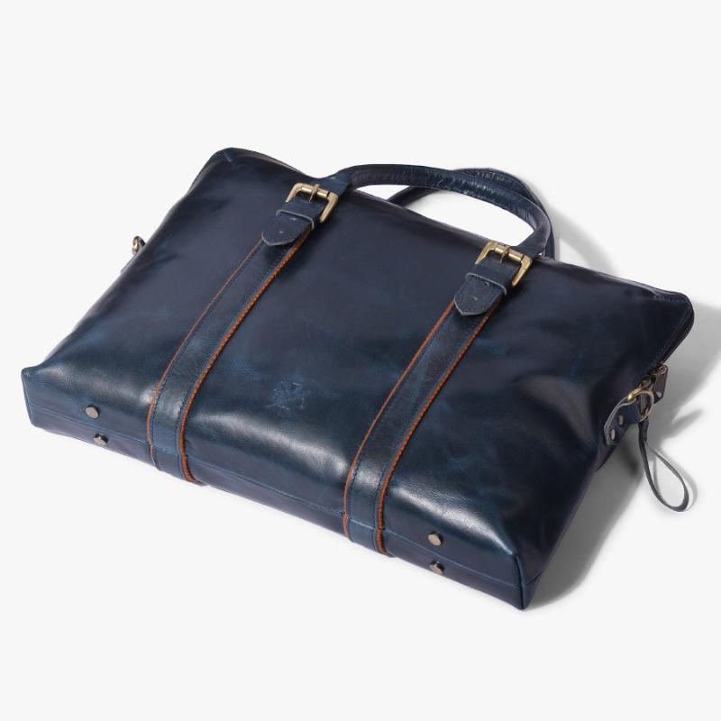 Navy blue genuine leather laptop bag with dual top handles, buckle detailing, and zipper closure from The Leather Warehouse.