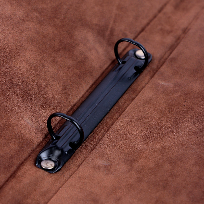 Black metal strap with two hooks on a brown leather menu cover 
