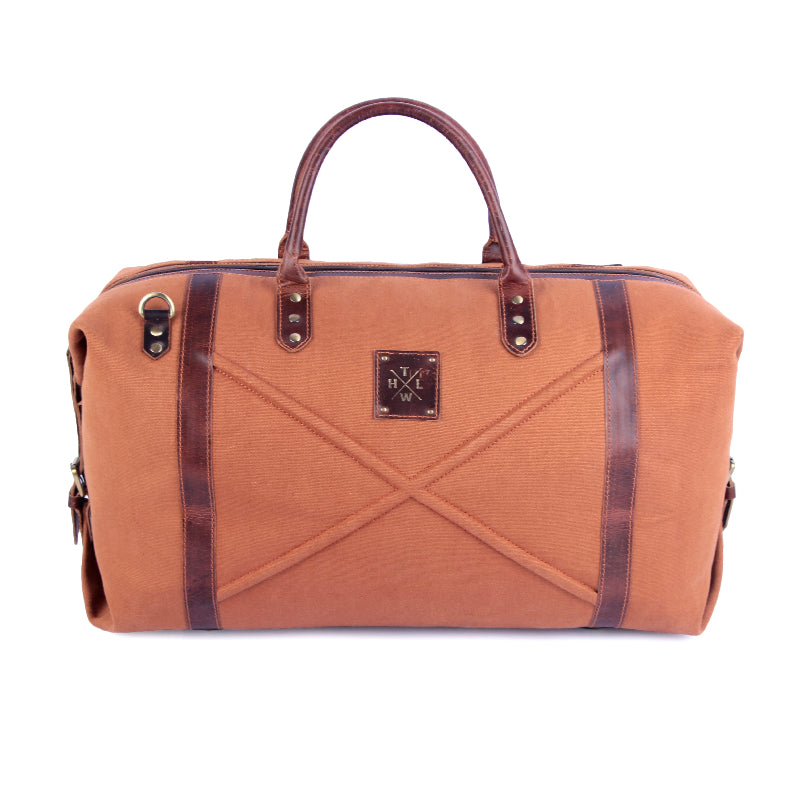 Brown duffel bag with leather accents on a white background