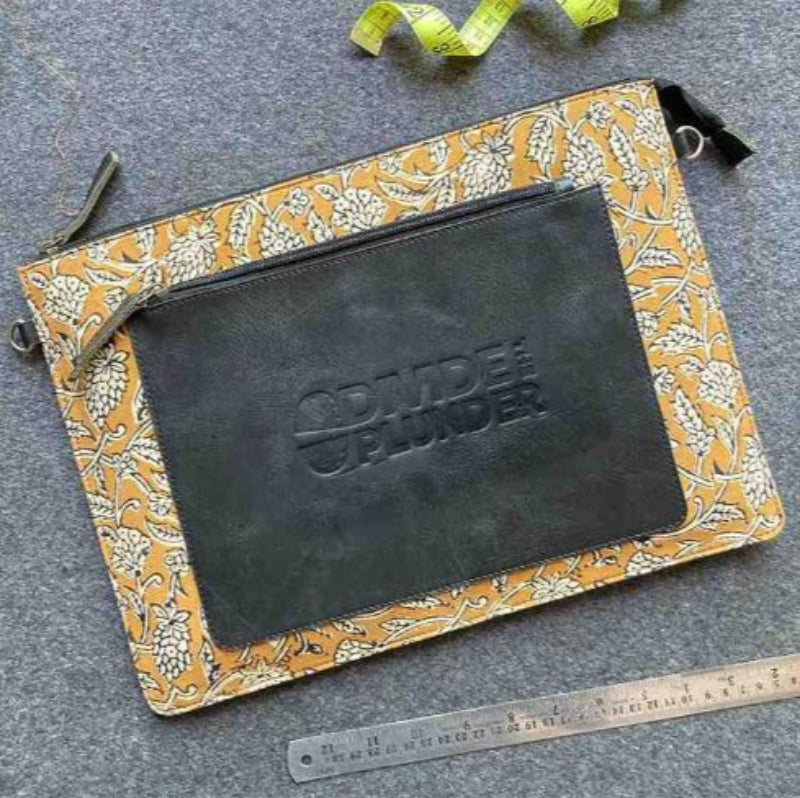 Floral-patterned pouch with 'Camden Planner' branding on a gray surface with tools.