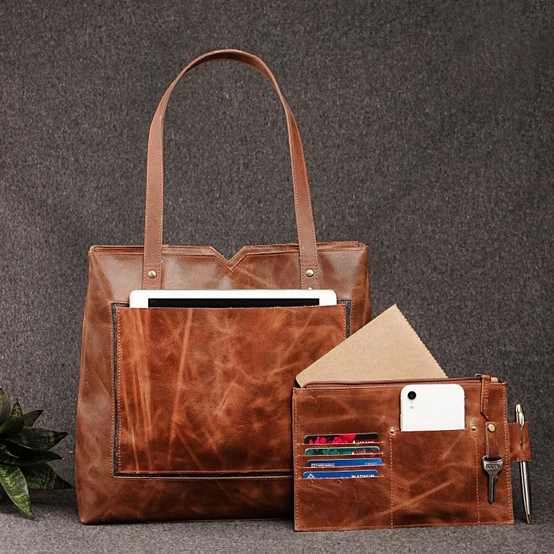 Brown leather tote bag with matching leather wallet holding tablet phone cards and notebook