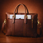 Brown leather briefcase with gold accents on a wooden surface