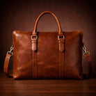 Brown leather briefcase with a strap on a dark background