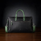 Black leather briefcase with green handles and straps on a dark background