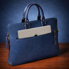 Blue leather briefcase with a laptop inside on a wooden surface and blue background