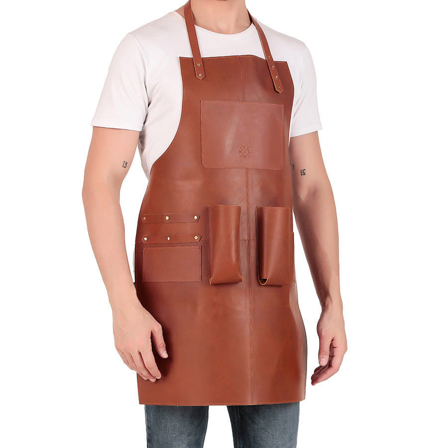 Man wearing a brown leather apron with multiple pockets, designed for bartenders or craftsmen, standing against a white background.