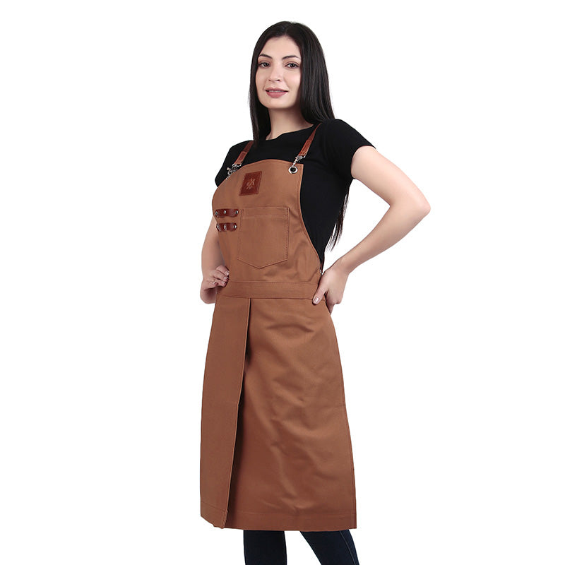 Woman in brown apron over black T shirt posing on white background showing a professional work apron