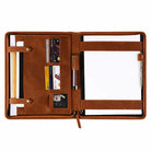 Brown leather portfolio organizer opened to show card slots, document compartments, pen holders, and a notepad.