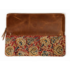 A brown leather sleeve  with a lower flap featuring an intricate red, beige, and blue floral pattern, shown against a plain white background.