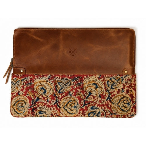 A brown leather sleeve  with a lower flap featuring an intricate red, beige, and blue floral pattern, shown against a plain white background.