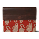 Brown leather laptop sleeve with red and beige pattern on a white background