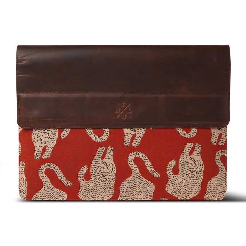 Brown leather laptop sleeve with red and beige pattern on a white background