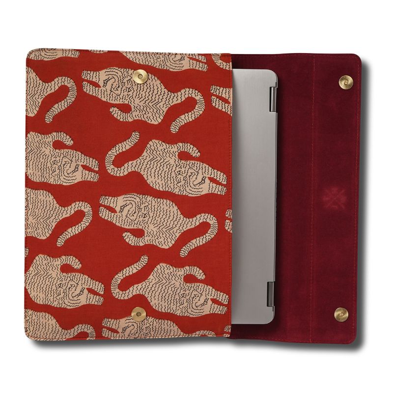 Red laptop sleeve with beige tiger pattern holding a silver device on a white background