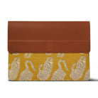 Brown leather and yellow fabric laptop sleeve with a pattern on a white background