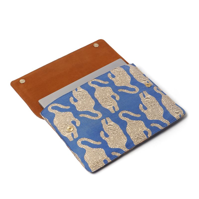 Blue laptop sleeve with beige tiger pattern and brown flap on a white background