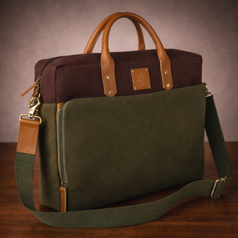 Green and brown canvas & leather briefcase on a wooden surface with a neutral background