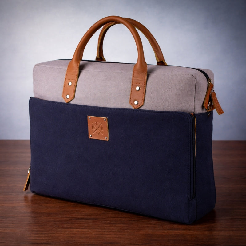 Two-toned bag with canvas  handles and a visible brand logo on a wooden surface.